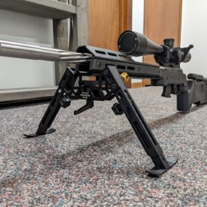 Rimfire Drop-In precision rifle setup with bipod attached, featuring a stainless steel barrel and adjustable scope mounted on a custom action.