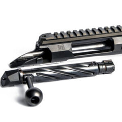 Close-up of a Deadline 2.0 Action barreled action in black steel with a spiral fluted bolt and integrated Picatinny rail for precision firearm assembly and customization.